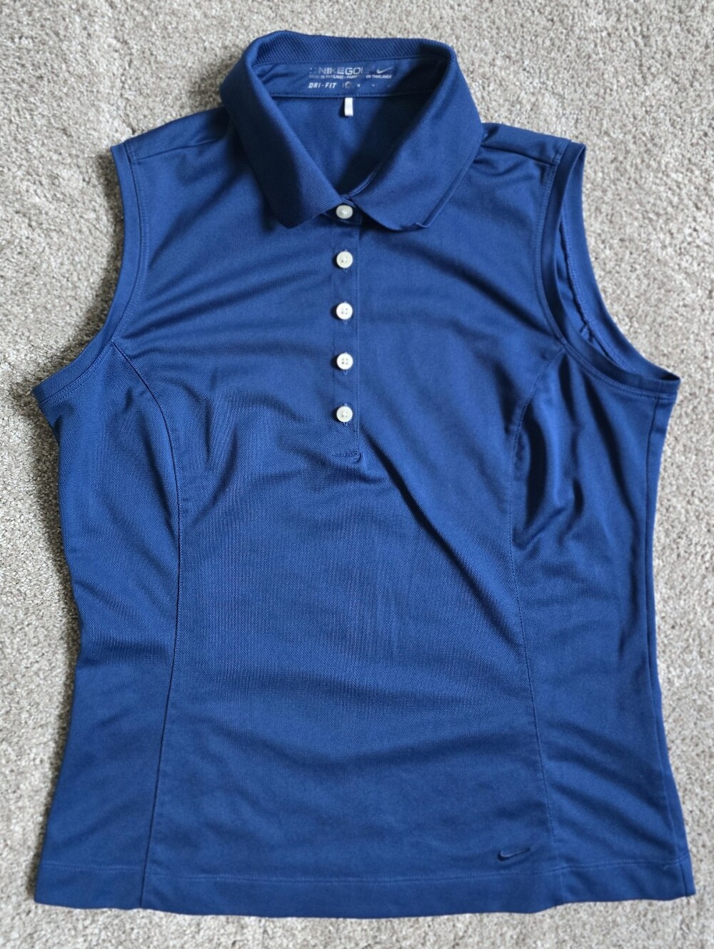 Royal blue sleeveless Nike Golf polo featuring a white-buttone